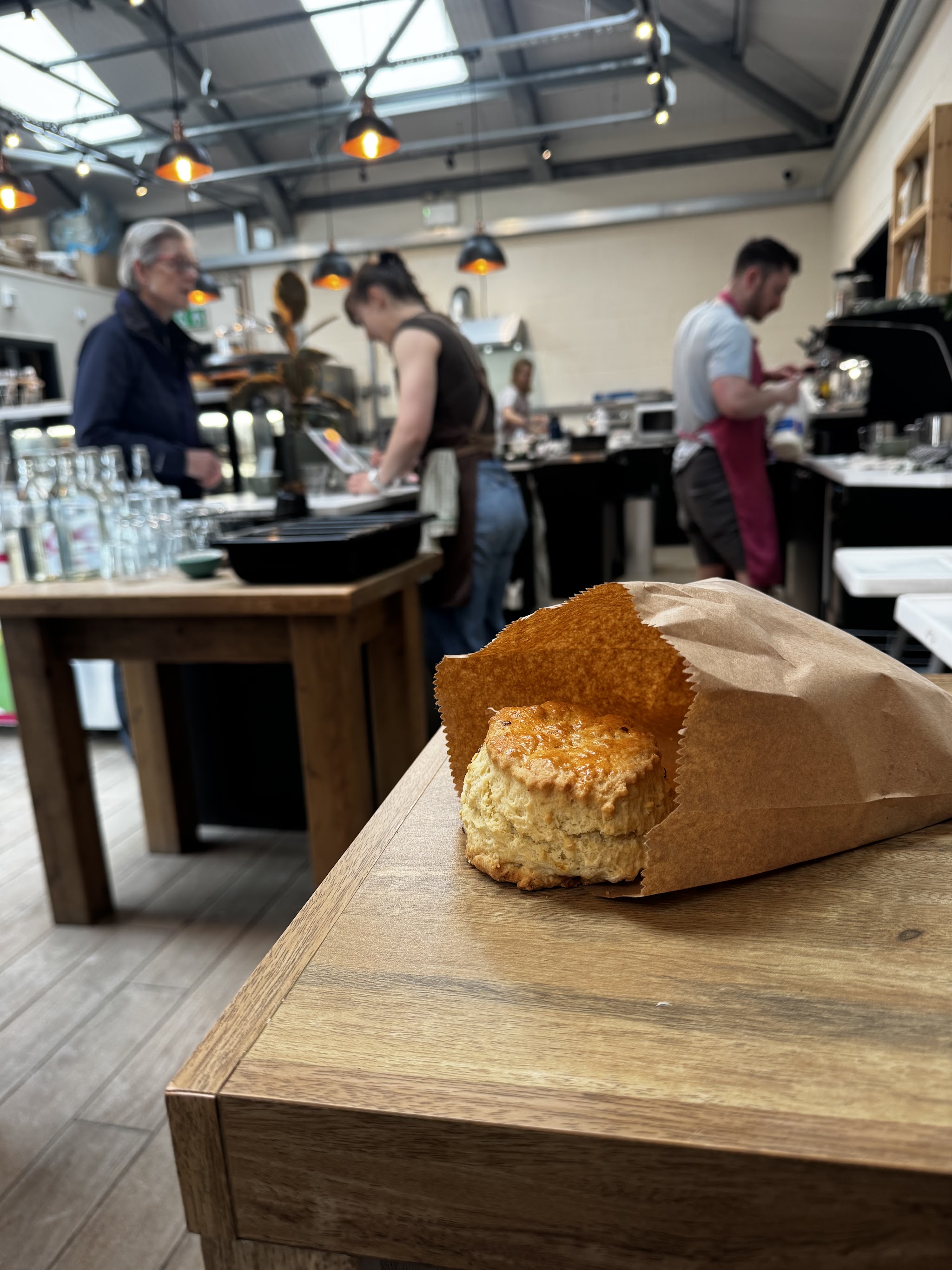 A scone on the counter with the coffee shop behind it