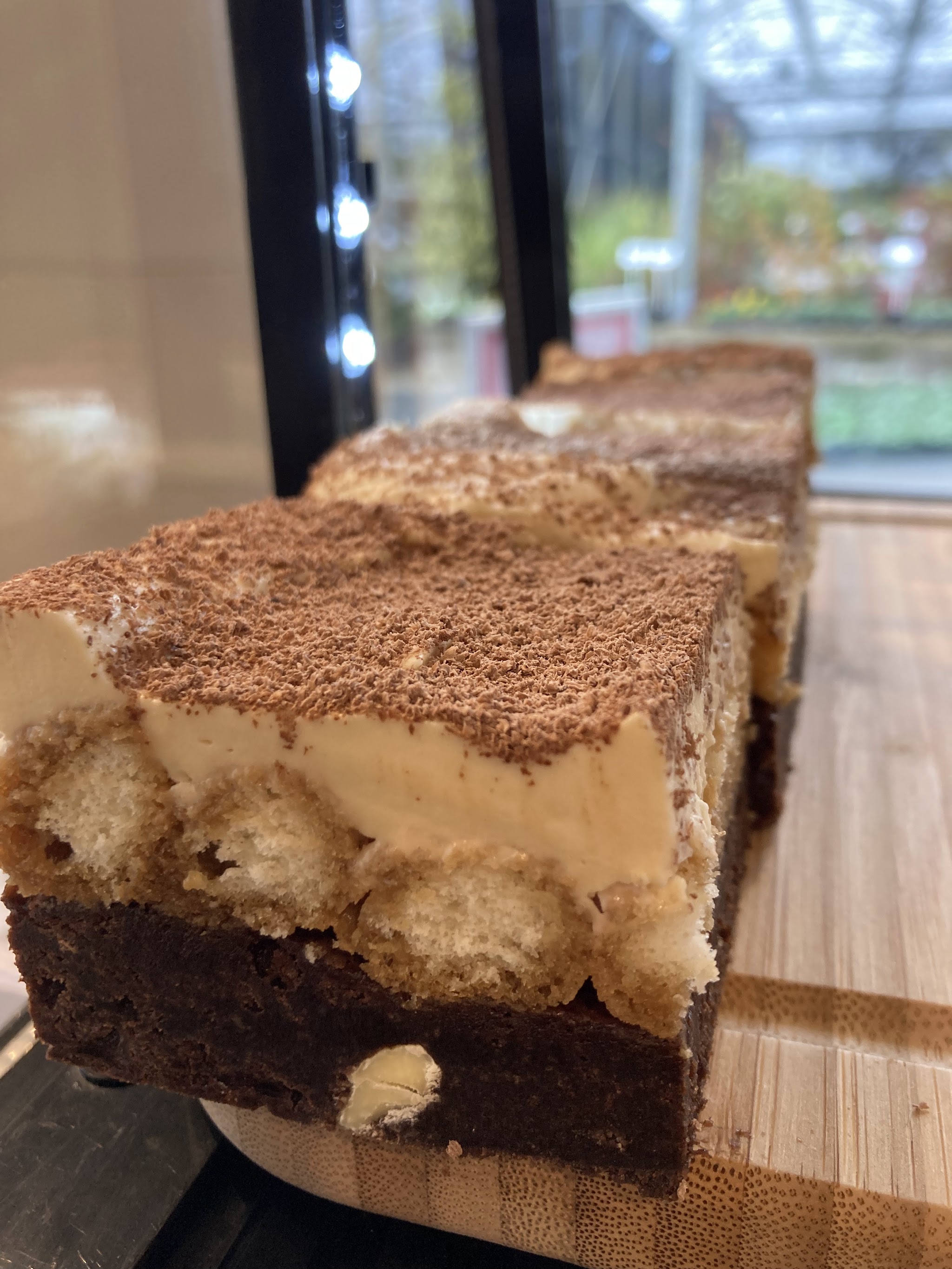 A slice of layered cake with a cocoa-dusted top